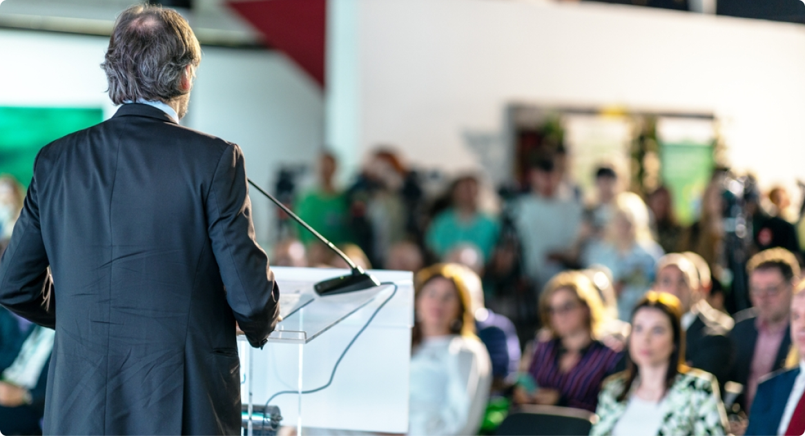 Speaker addressing an audience from a podium at a FOAP conference